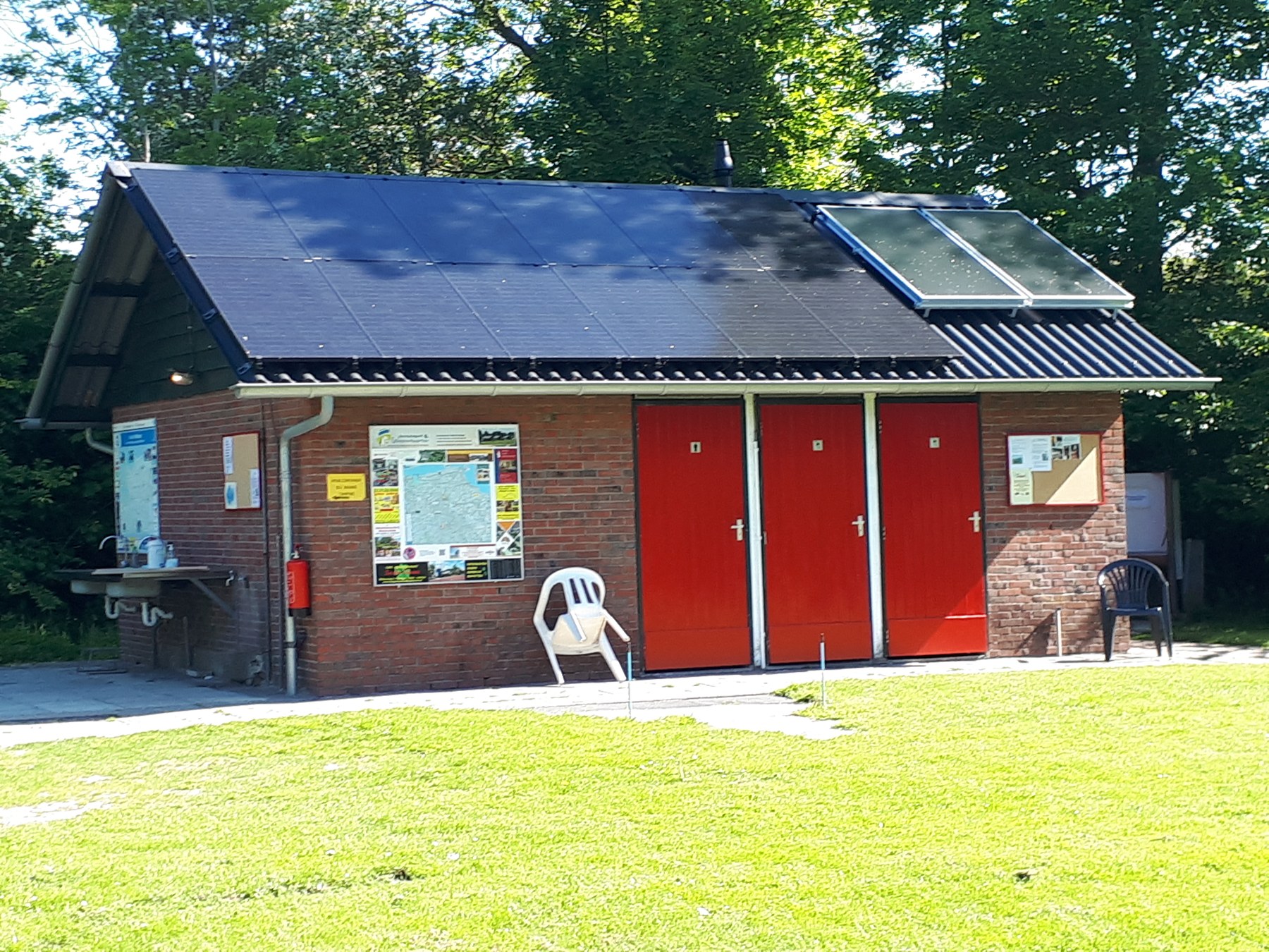 Het sanitairgebouw met zonnecollectoren